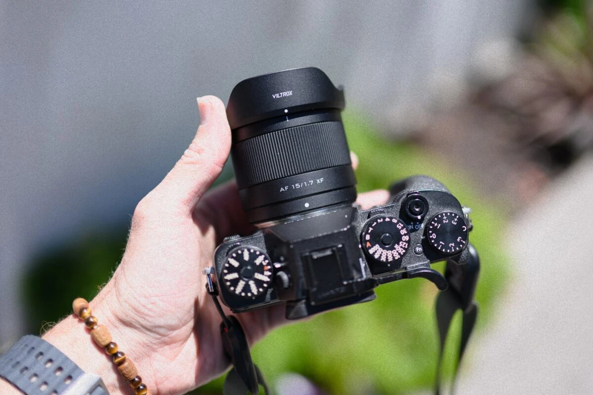 Ширококутний об'єктив Viltrox AF 15mm f/1.7 Air з встановленою блендою на чорній камері Fujifilm на вулиці