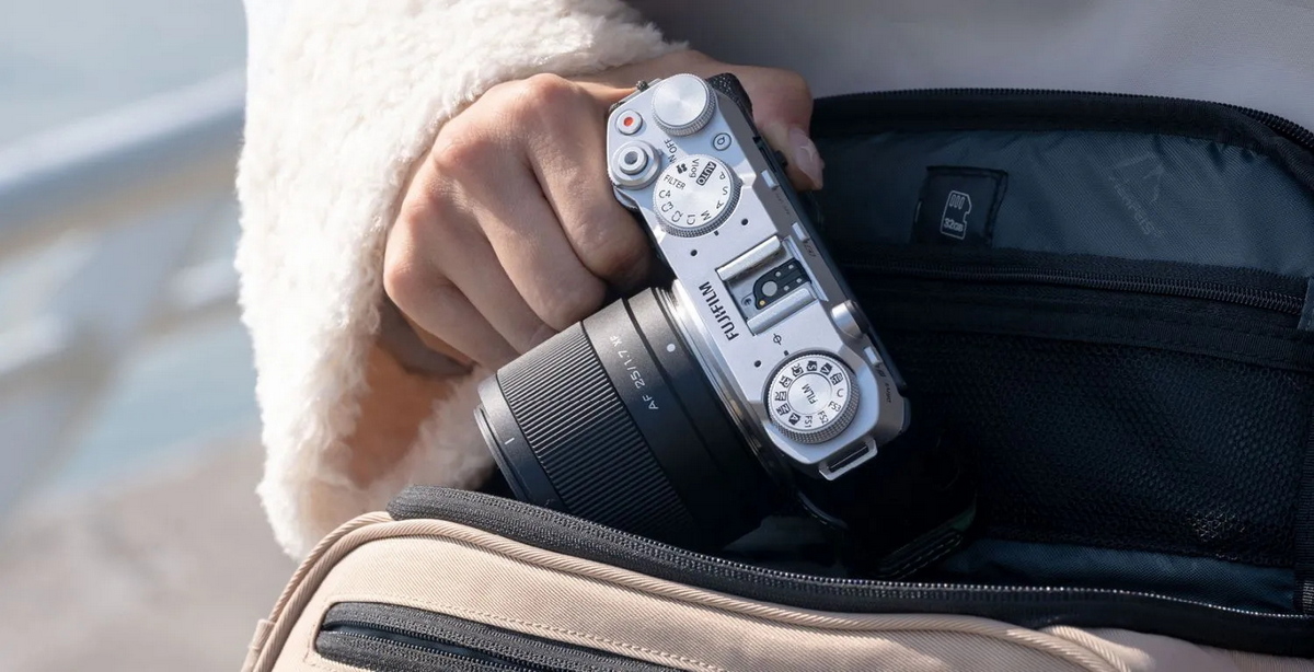 Компактна камера Fujifilm з об'єктивом Viltrox AF 25mm f/1.7 Air під час виймання з невеликої дорожньої сумки