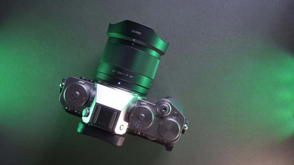 Об'єктив Viltrox AF 56mm f/1.7 Air з пелюстковою блендою на сріблястій камері Fujifilm X-T5 у зеленому студійному світлі